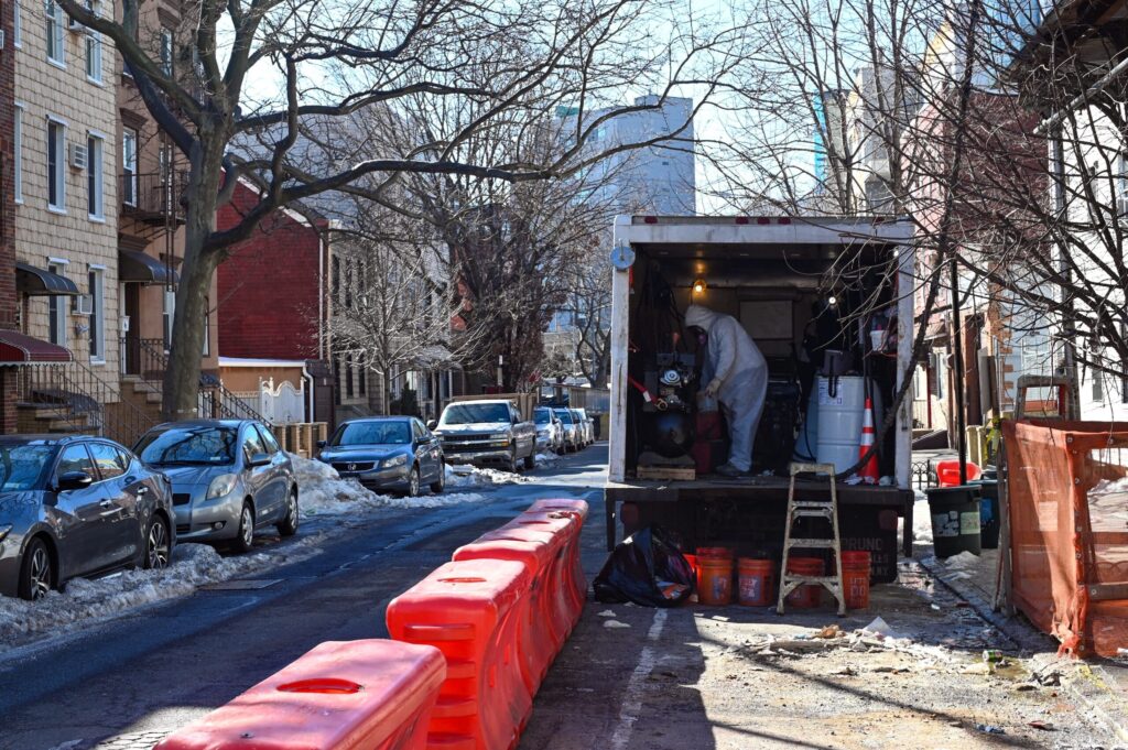 Person in hazmat suit safely handling hazardous material transportation.
